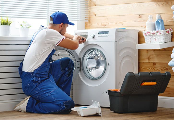 Plumber repair washing machine shutterstock_1051194281